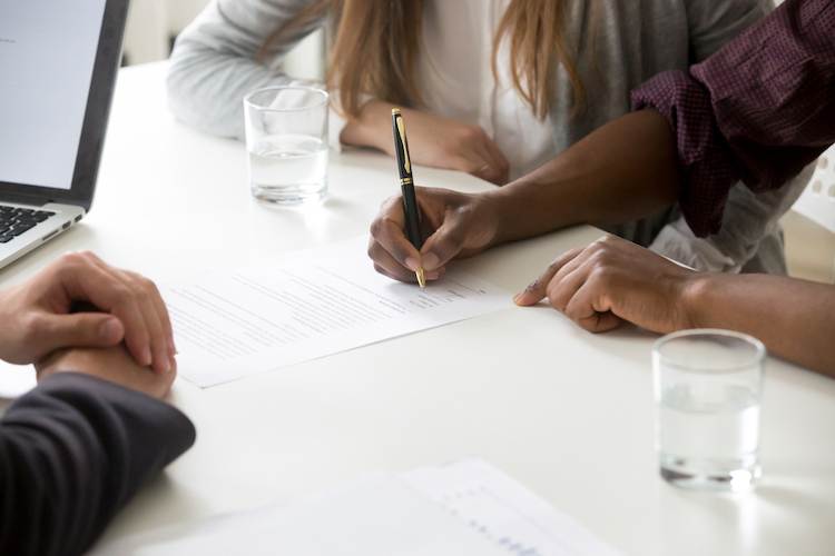 man signing documents