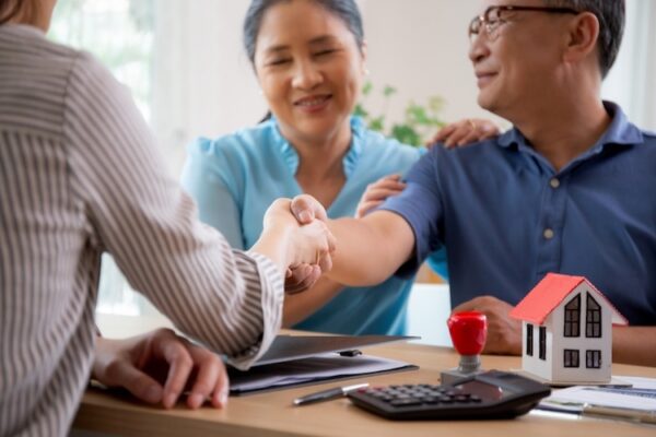 elderly couple shaking hands with person