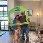 2 people posing holding dsld sign