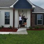 2 people jumping outside their house