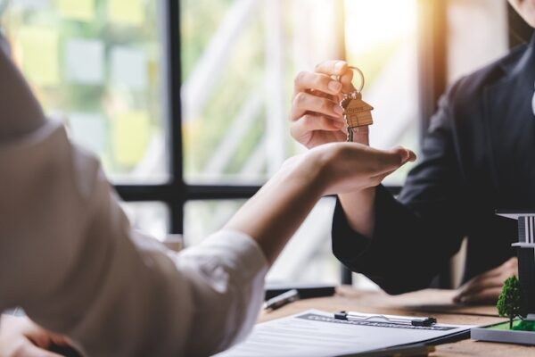 person handing house keys over to another person