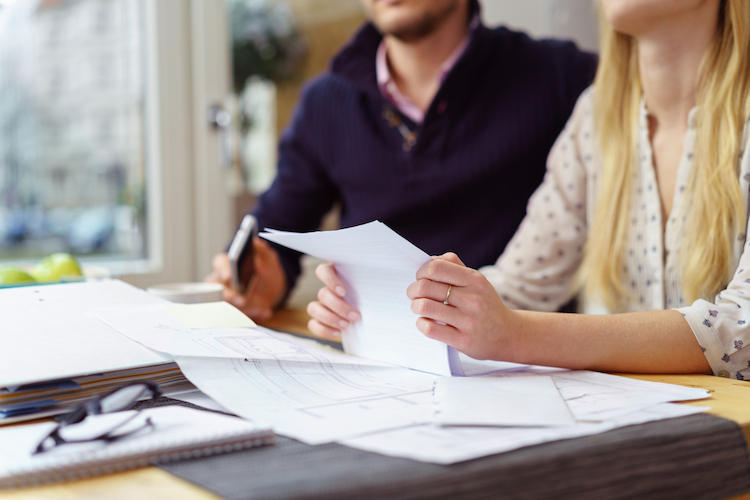 a couple holding and reading paper documents