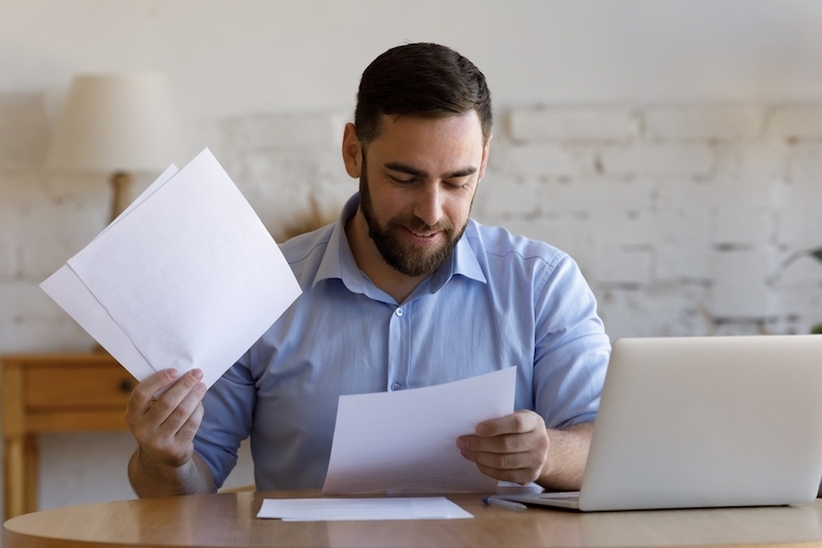 man looking through paperwork at a desk