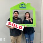 couple posing with sold sign