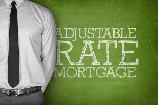 adjustable rate mortgage on chalk board with man figure in tie in front