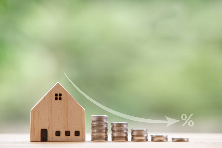 miniature model wooden house with coin stacks beside