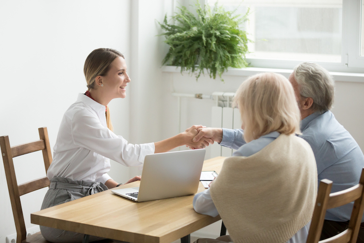 smiling female lawyer real estate agent with elderly clients
