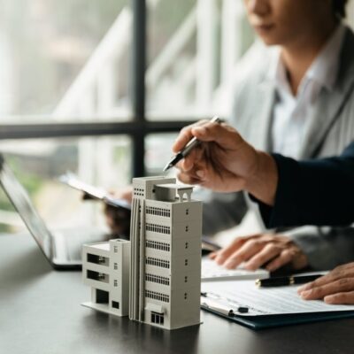 A pair of people reviewing a model of a condo to determine whether to purchase a condo vs a house