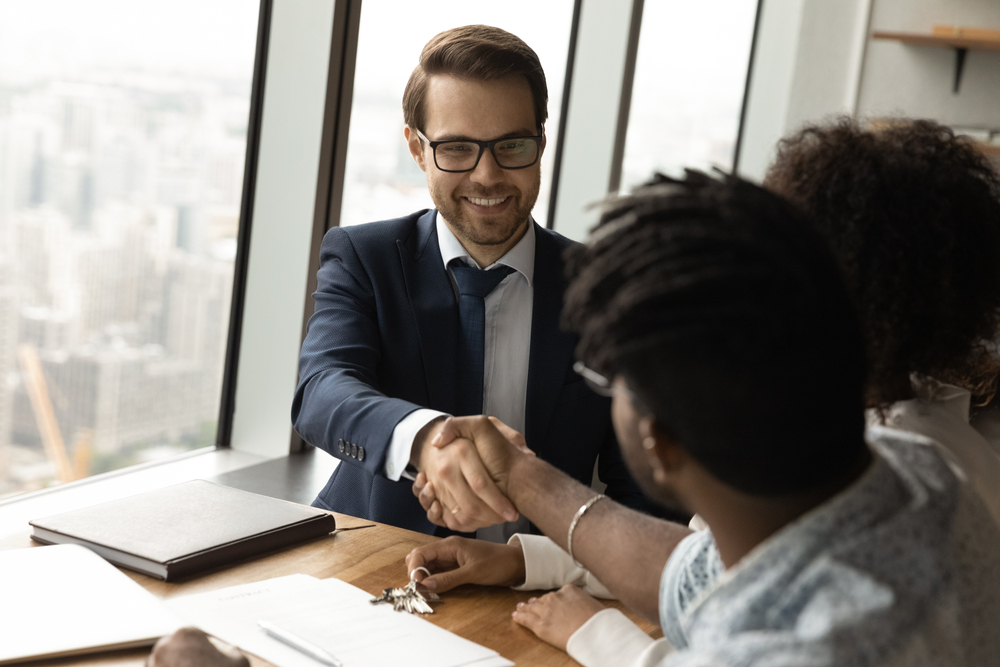 A loan advisor shaking a woman's hand