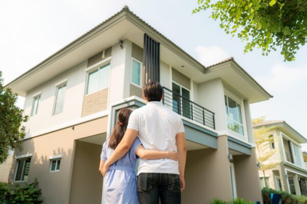 A couple in front of a multifamily home